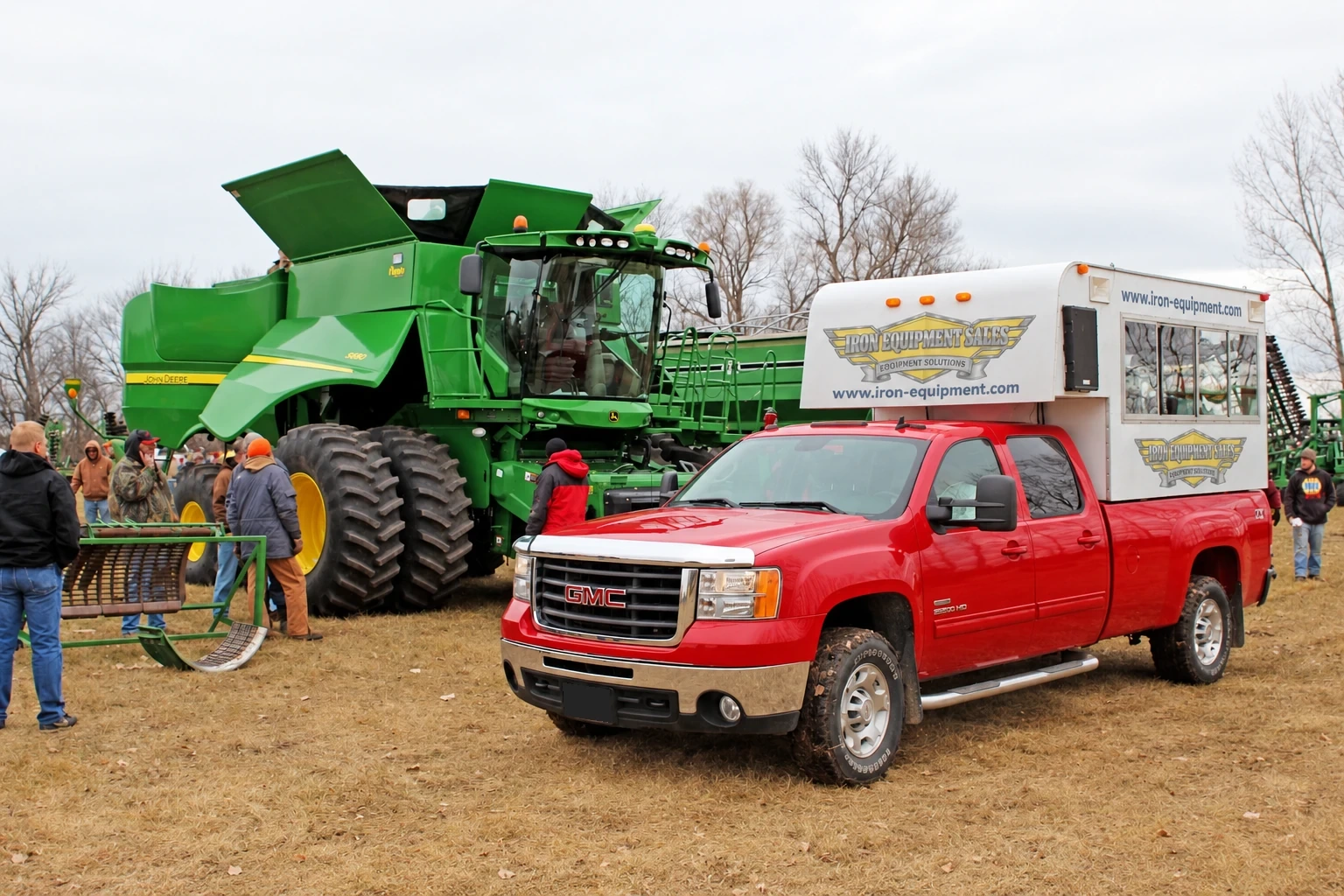 Auction truck beside a green combine